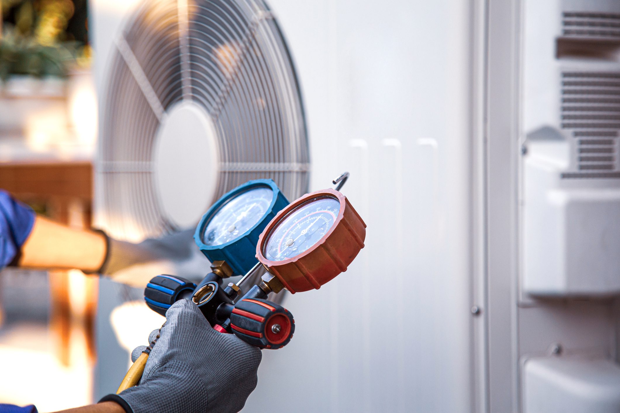 Heat and Air Conditioning, HVAC system service technician using measuring manifold gauge checking refrigerant and filling industrial air conditioner after duct cleaning maintenance outdoor compressor. HVAC machine surveying